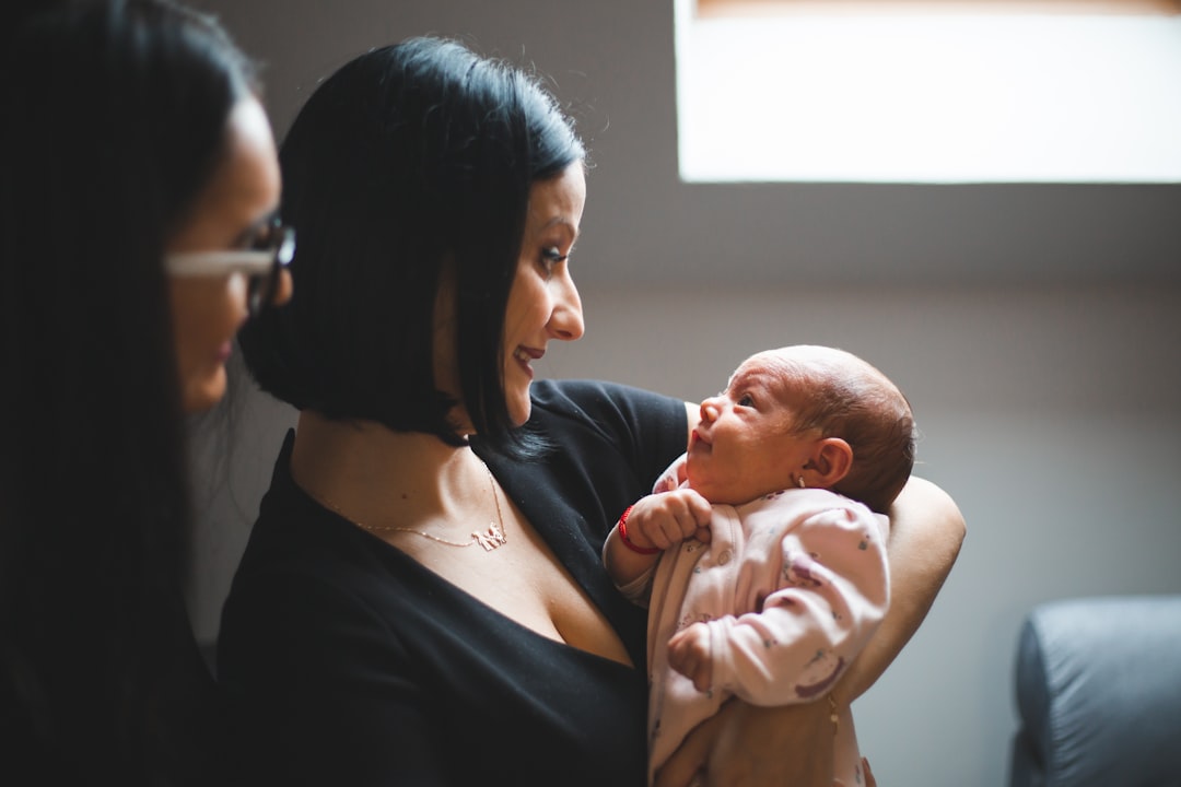 A mother holding her baby while reading a vaccination pamphlet
