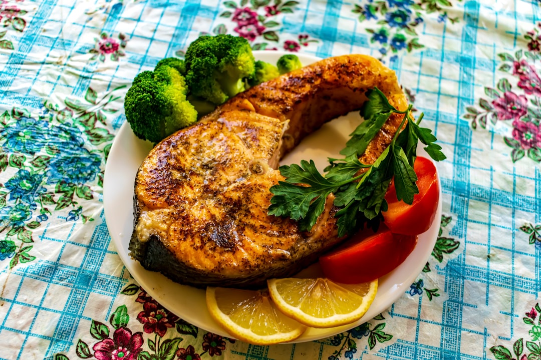 a plate of cooked salmon with lemon slices