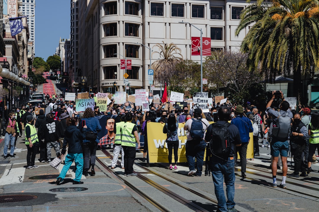 A large crowd of protestors holding signs in a park in San Francisco
